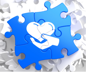 Puzzle piece with a hand holding a heart